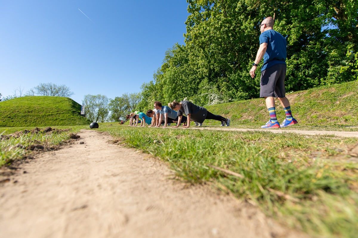 Bootcampgroep traint buiten onder begeleiding van een trainer